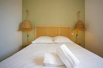 a bed with white sheets and towels on it at Résidence Casa di Sole in Sotta