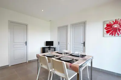 a dining room with a table and white walls at Résidence Casa di Sole in Sotta