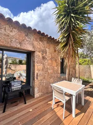 a wooden deck with a table and a grill at Maison Di Fiori, location neuve avec piscine in Porto-Vecchio