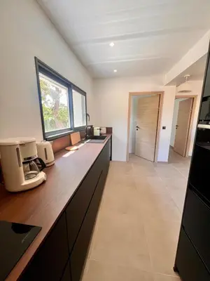 a kitchen with a counter with a sink and a window at Maison Di Fiori, location neuve avec piscine in Porto-Vecchio