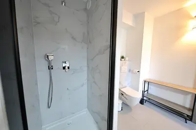 a shower with a glass door in a bathroom at U Bellu Paradisu - T3 vue mer, piscine, plage privé in Pianottoli-Caldarello