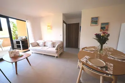 a living room with a couch and a table at U Bellu Paradisu - T3 vue mer, piscine, plage privé in Pianottoli-Caldarello