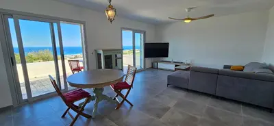 a living room with a table and a couch at BELLA VISTA-Wifi-VUE MER PANORAMIQUE in Sari Solenzara