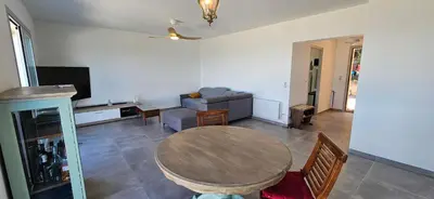 a living room with a table and a couch at BELLA VISTA-Wifi-VUE MER PANORAMIQUE in Sari Solenzara