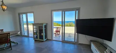 a living room with a large flat screen tv on the wall at BELLA VISTA-Wifi-VUE MER PANORAMIQUE in Sari Solenzara