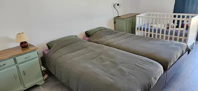 a large bed in a bedroom with a crib at BELLA VISTA-Wifi-VUE MER PANORAMIQUE in Sari Solenzara