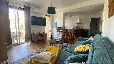 a living room with a blue couch and a table at Confort et modernité Ajaccio in Ajaccio