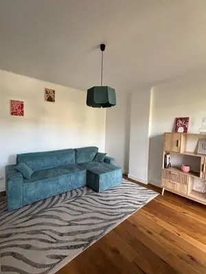 a living room with a blue couch and a rug at Confort et modernité Ajaccio in Ajaccio