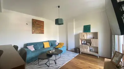 a living room with a blue couch and a table at Confort et modernité Ajaccio in Ajaccio