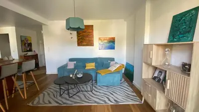 a living room with a blue couch and a table at Confort et modernité Ajaccio in Ajaccio