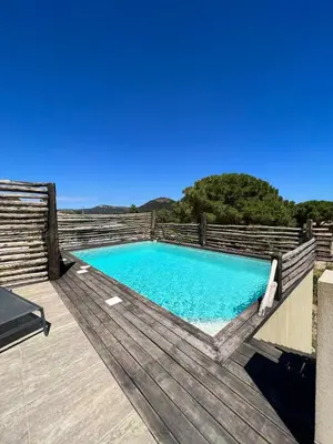 a swimming pool on top of a wooden deck at Villa Ghjulia in Porto-Vecchio
