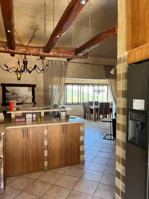 a kitchen with wooden cabinets and a dining room at Villa Ghjulia in Porto-Vecchio