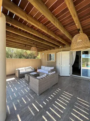 a living room with couches and a patio at Villa Ghjulia in Porto-Vecchio