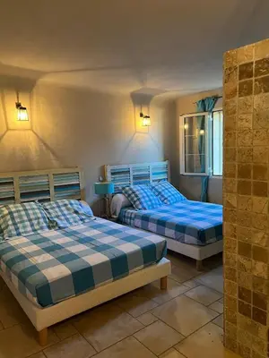 two beds in a room with blue and white at Villa Ghjulia in Porto-Vecchio