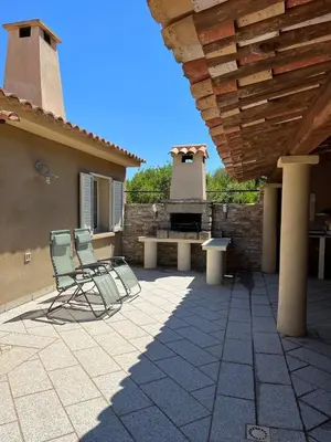 two chairs and a picnic table on a patio at Villa Ghjulia in Porto-Vecchio