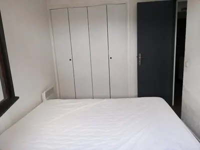 a bedroom with a white bed and a closet at T2 log entier Porticcio 35m piscine-mer-resto 400m in Grosseto-Prugna