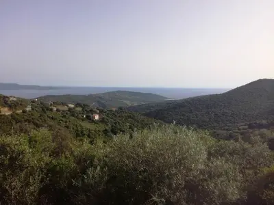 a view of a mountain with the ocean in the background at T2 log entier Porticcio 35m piscine-mer-resto 400m in Grosseto-Prugna