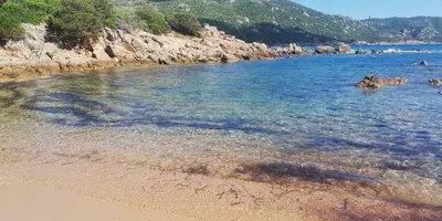 a body of water with a beach and rocks at T2 log entier Porticcio 35m piscine-mer-resto 400m in Grosseto-Prugna
