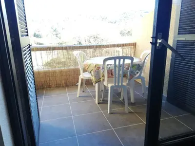 a patio with a table and chairs on a balcony at T2 log entier Porticcio 35m piscine-mer-resto 400m in Grosseto-Prugna