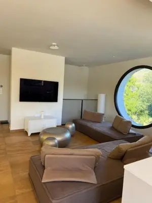 a living room with a couch and a large window at luxe et sérénité in Lecci