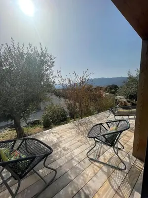 three chairs sitting on a deck with a view of the water at luxe et sérénité in Lecci