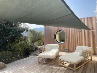 a patio with two chairs and a mirror at luxe et sérénité in Lecci