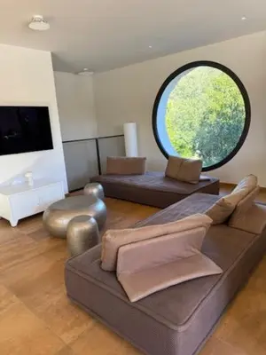 a living room with a couch and a round window at luxe et sérénité in Lecci