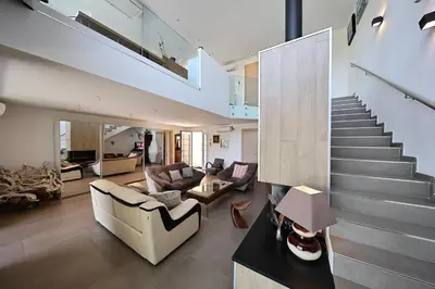 a kitchen and living room with white cabinets and tables at U Casaniddu - Villa entre mer et montagne, piscine in Viggianello