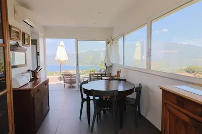 a balcony with a table and chairs and a view at U Casaniddu - Villa entre mer et montagne, piscine in Viggianello