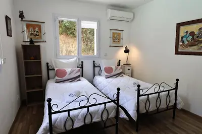 a bedroom with a large white bed with red pillows at U Casaniddu - Villa entre mer et montagne, piscine in Viggianello