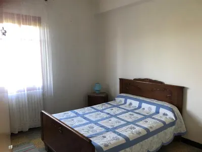 a bedroom with a bed with a blue comforter and a window at Lyvia in Serra-di-Ferro