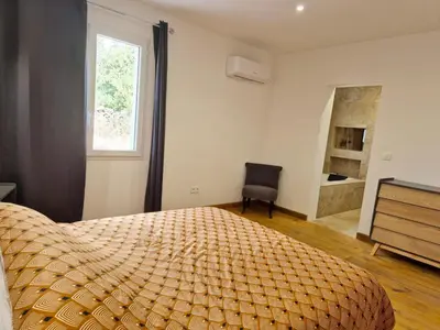 a bedroom with a large bed and a chair and a window at Chambres d hôtes, calme et nature in Pianottoli-Caldarello