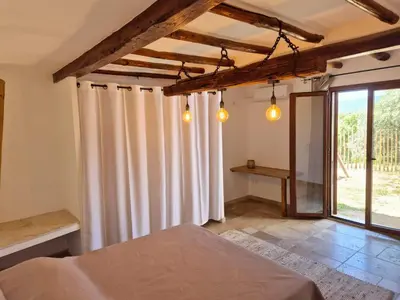 a bedroom with a bed with curtains and a window at Chambres d hôtes, calme et nature in Pianottoli-Caldarello