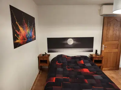 a bedroom with a bed and a painting on the wall at Deux pièces tout confort Monacia d'Aullène in Monacia-dʼAullène