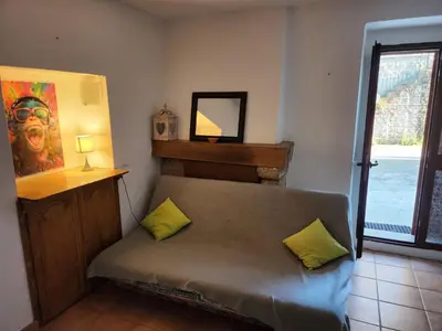 a room with a couch with two pillows and a mirror at Deux pièces tout confort Monacia d'Aullène in Monacia-dʼAullène