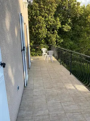 a balcony with a table and chairs on a building at u caseddu in Olivese