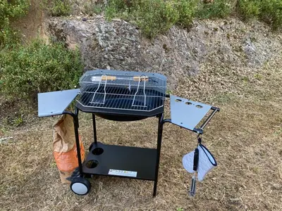 a grill sitting on the ground in the grass at u caseddu in Olivese
