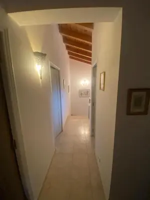 an empty hallway with a light on the wall and a hallwayngthngthngthngth at u caseddu in Olivese