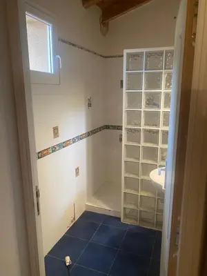a bathroom with a sink and a shower with blue tiles at u caseddu in Olivese