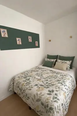 a white bed in a bedroom with pictures on the wall at Grand studio neuf, lumineux et au calme ! Tout équipé - Ajaccio in Ajaccio