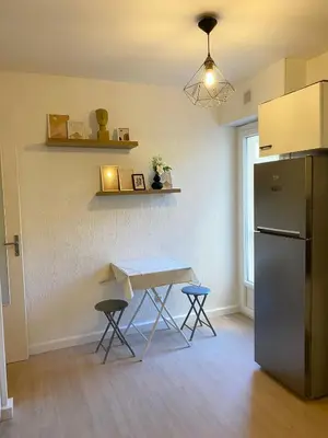 a living room with a tv and a table at Grand studio neuf, lumineux et au calme ! Tout équipé - Ajaccio in Ajaccio