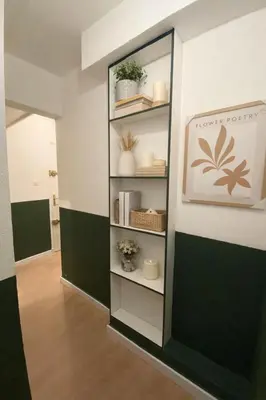 a book shelf in a room with a picture on the wall at Grand studio neuf, lumineux et au calme ! Tout équipé - Ajaccio in Ajaccio