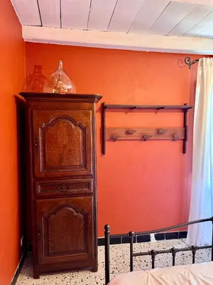 a bedroom with a wooden cabinet and a bed at Maison traditionnelle avec vues sur St Michel in Murato