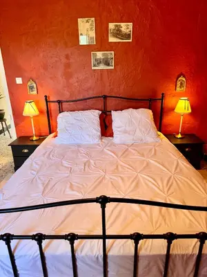 a bed in a bedroom with two lamps on tables at Maison traditionnelle avec vues sur St Michel in Murato