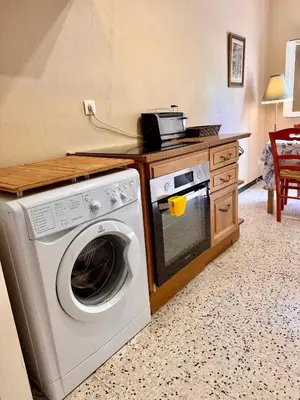 a kitchen with a washing machine and a counter at Maison traditionnelle avec vues sur St Michel in Murato