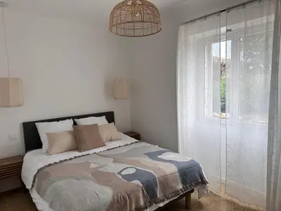 a white bedroom with a bed and a window at Sposata - maison avec piscine privée - Figari in Figari