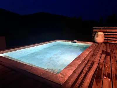 a swimming pool on a wooden deck at night at Sposata - maison avec piscine privée - Figari in Figari