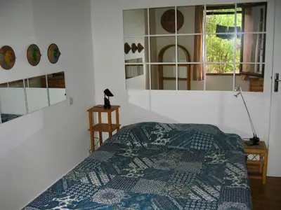 a bedroom with a bed and some mirrors on the wall at Villa Tarco in Porto-Vecchio