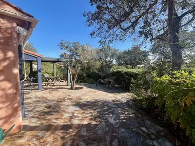 a patio of a house with trees and bushes at Villa Tarco in Porto-Vecchio