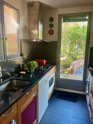 a kitchen with a sink and a stove and a window at Villa Tarco in Porto-Vecchio